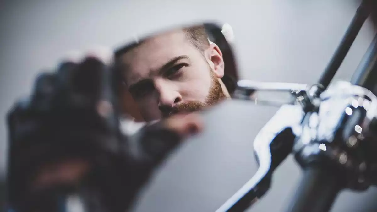 Man in the mirror on a motorbike.