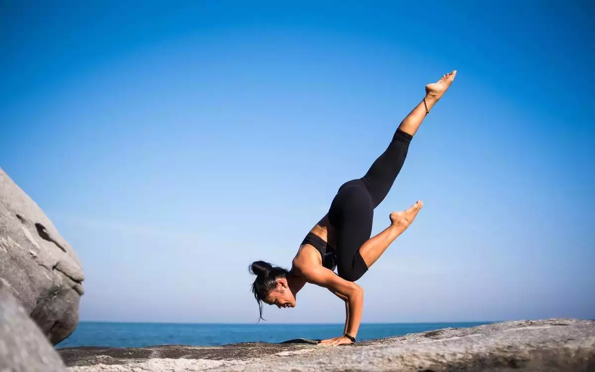 Woman doing yoga in the beach