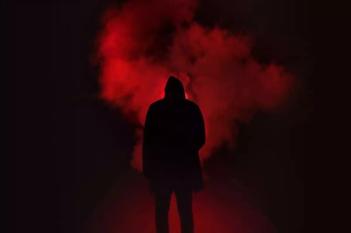 Man rounded of red smoke