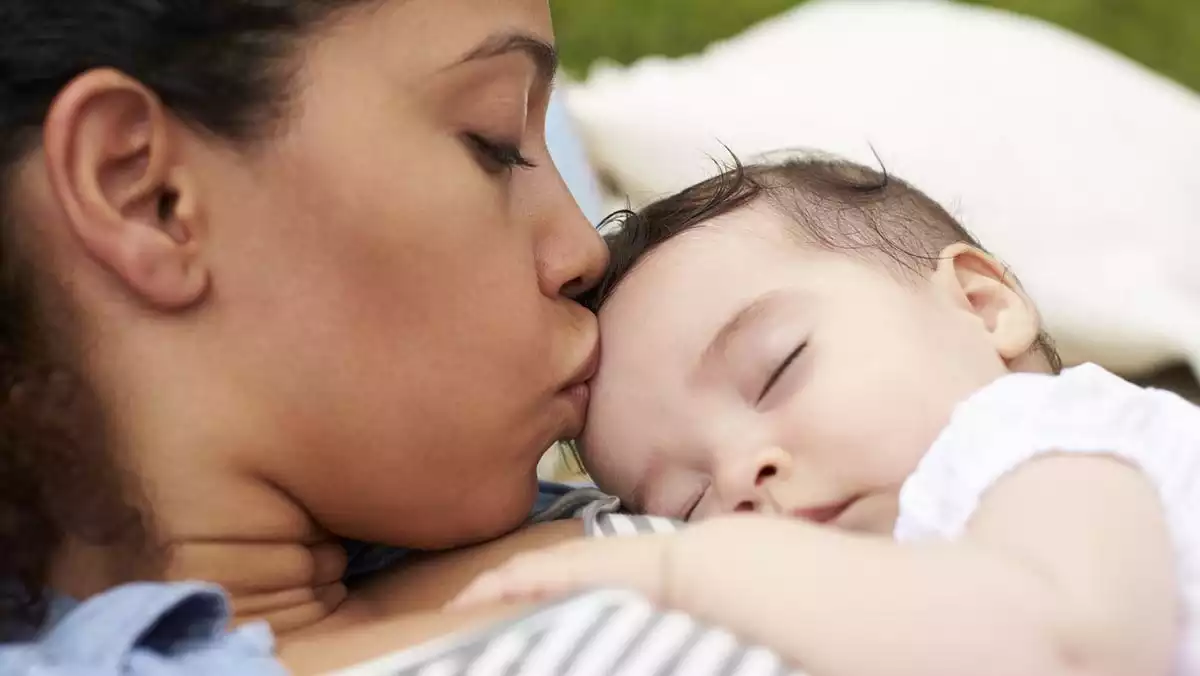 Mother kissing her child