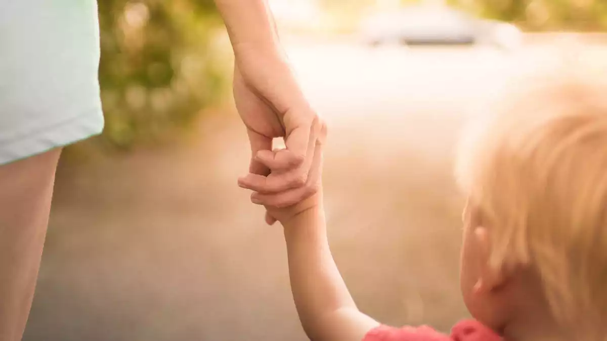 A mother holding her child's hand