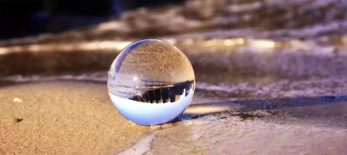 A marble on the floor with a reflection