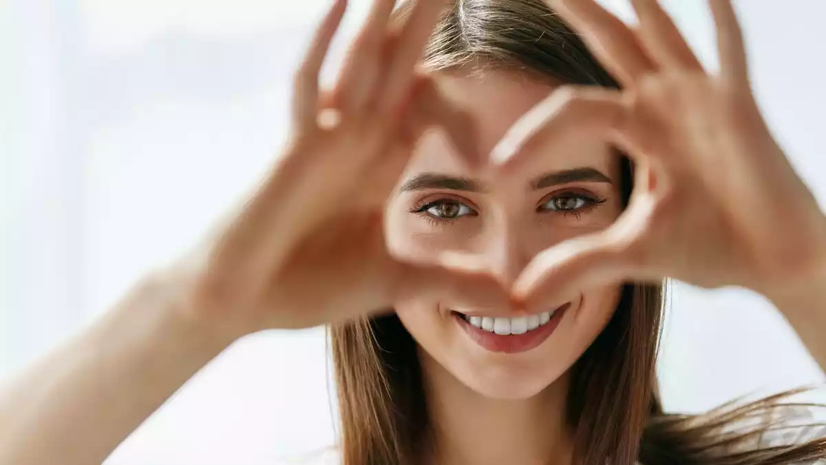 A woman making the shape of a heart with her hands