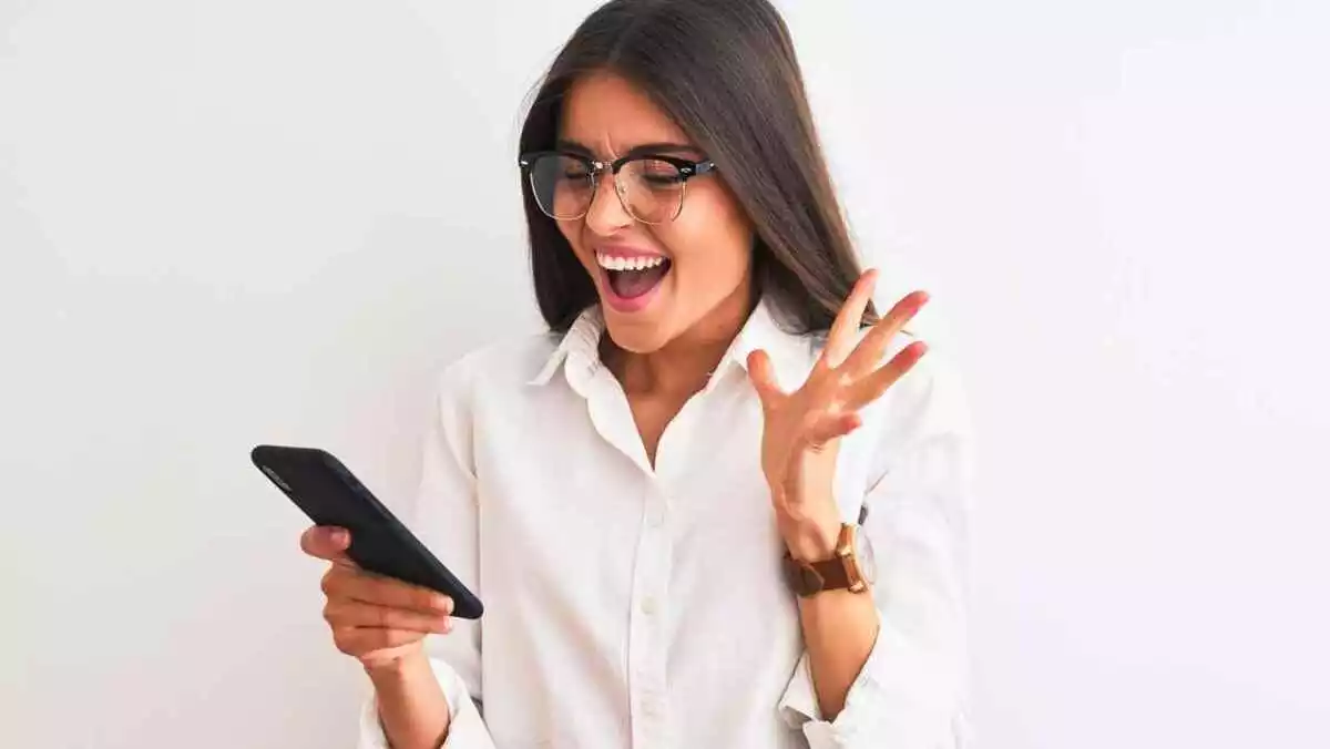 A surprised woman with a phone in her hands.