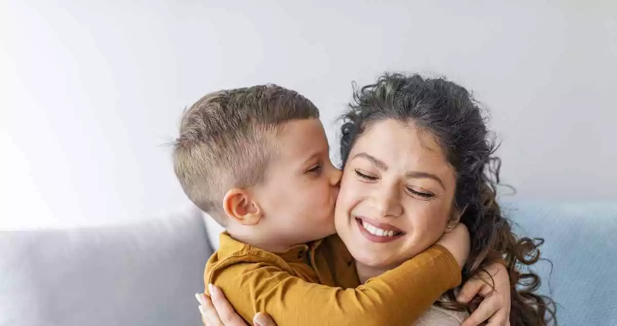 A kid kissing her mother