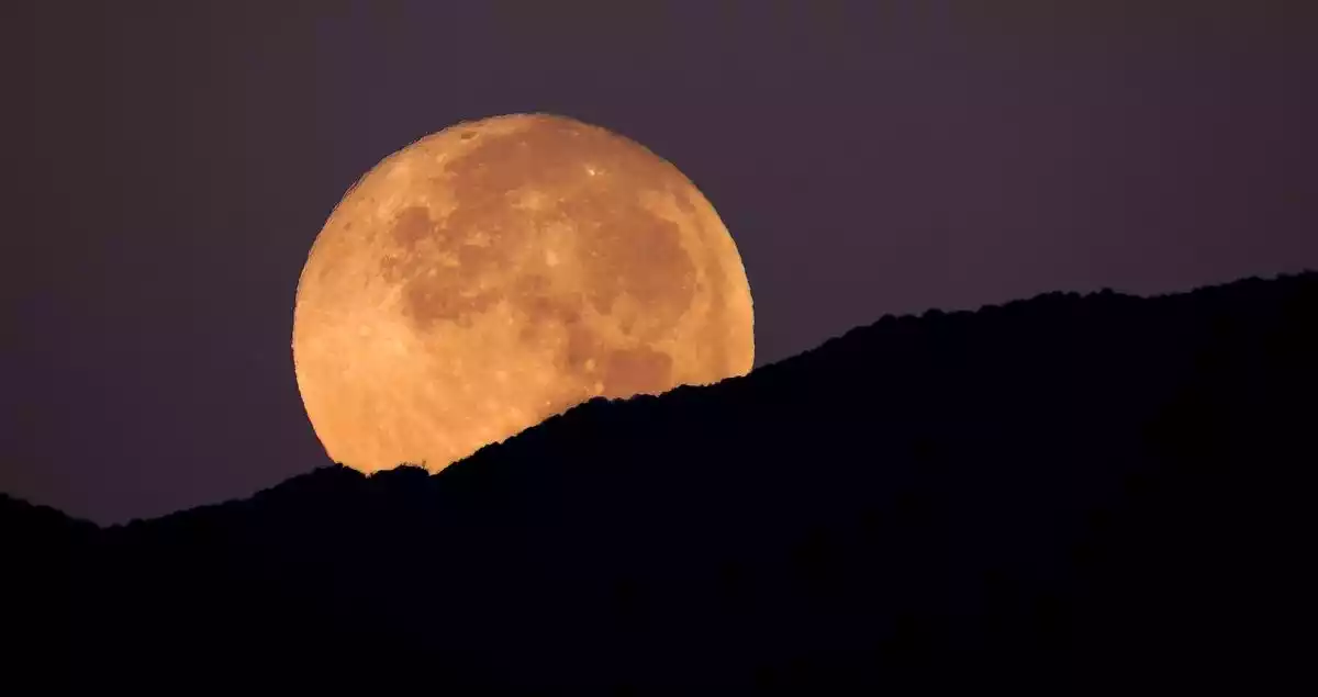 A supermoon behind a mountain