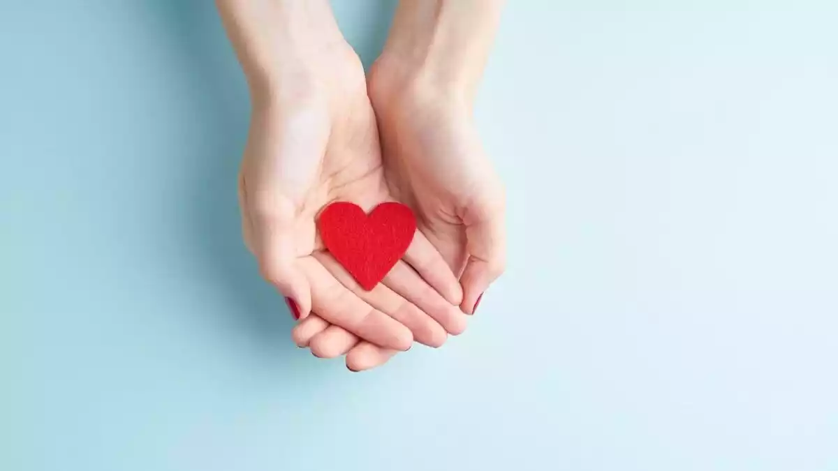 A woman holding a paper heart in her hands