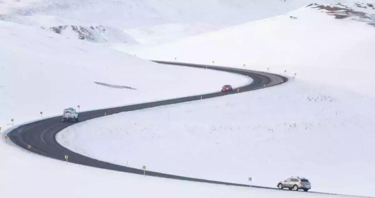 Snowed mountains and a road with some cars