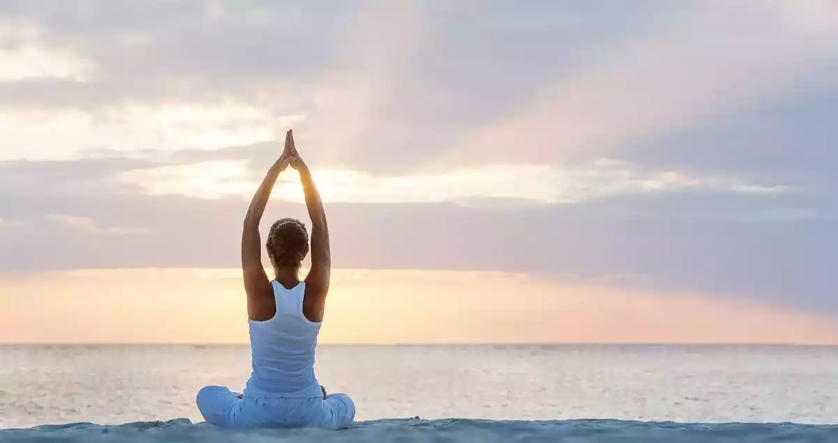 Woman doing yoga in the beach