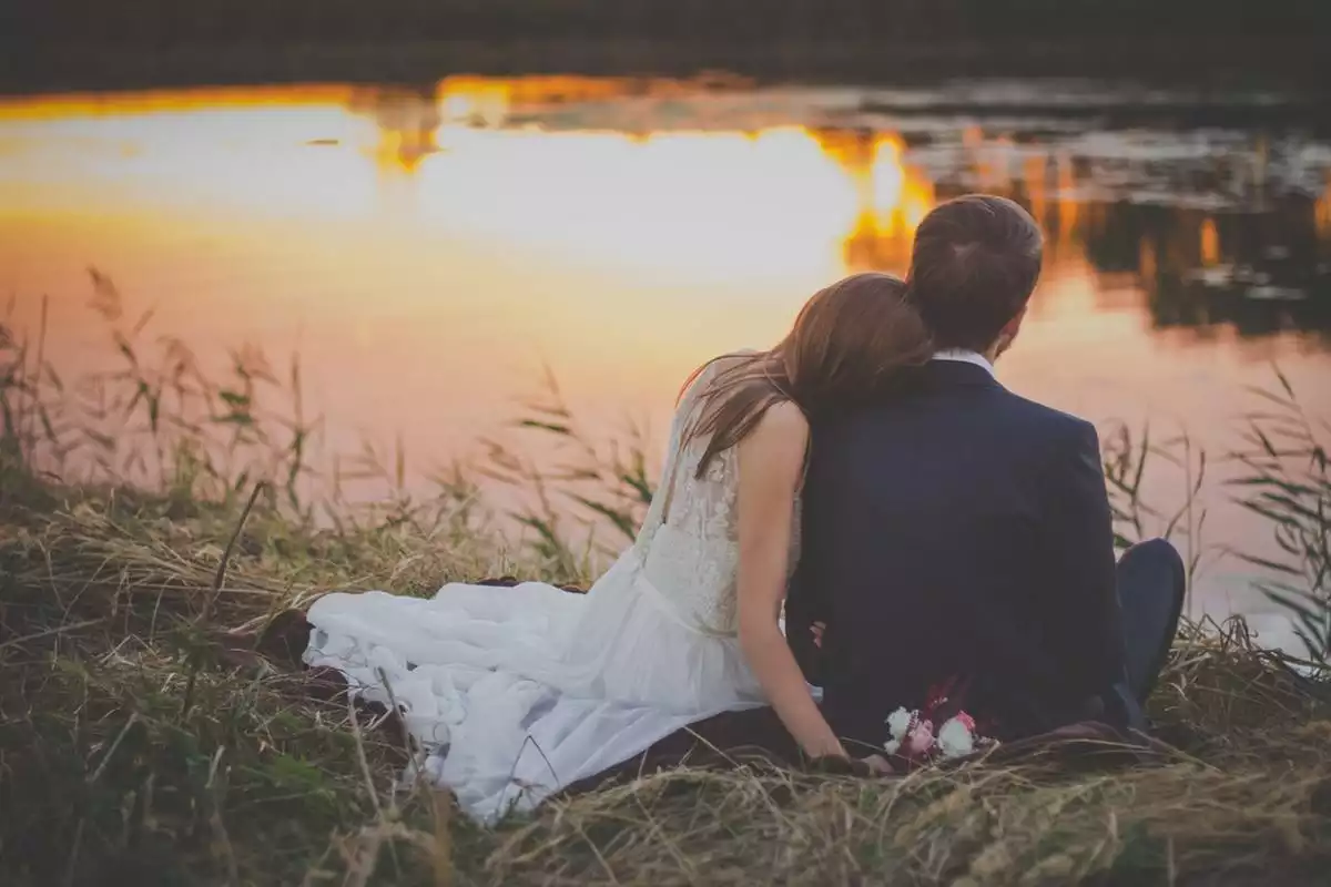Couple nouvellement marié assis devant la rivière