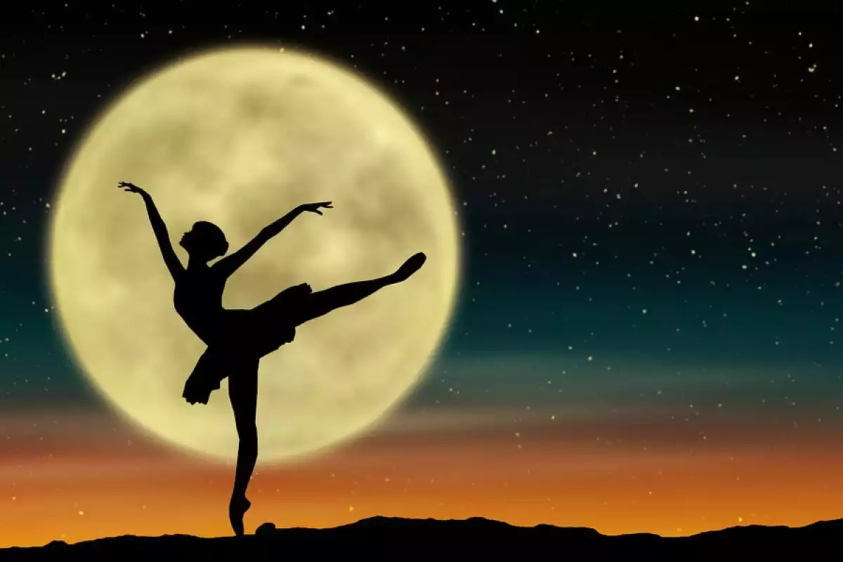 La silhouette d'une danseuse avec la pleine lune en arrière-plan