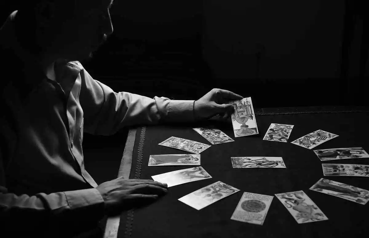 Photo en noir et blanc d'un homme lisant les cartes