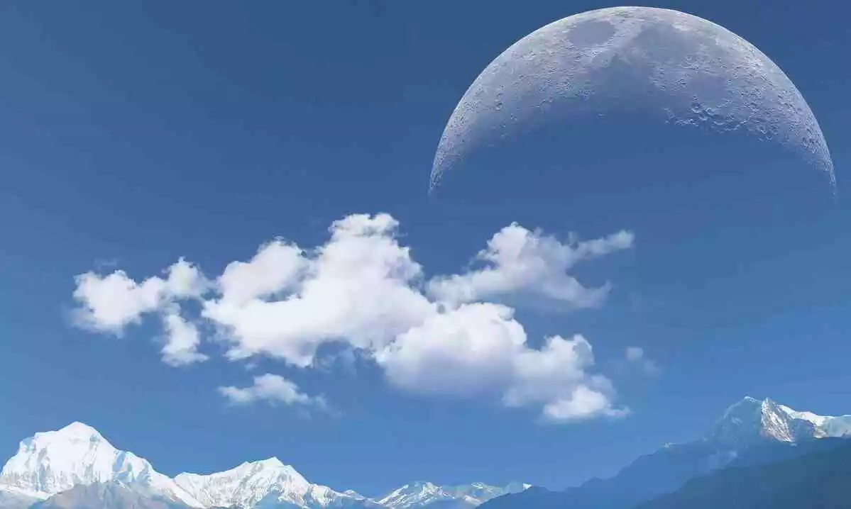 Photo d'une pleine lune sur fond de montagnes enneigées