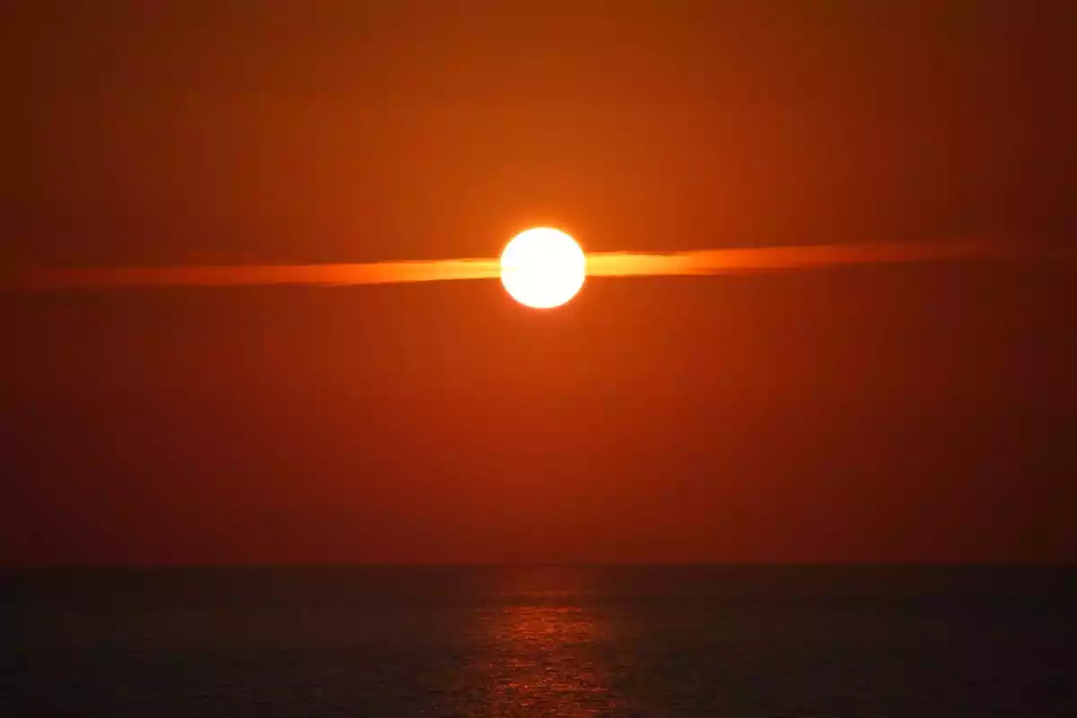 A picture of the sun in the middle of an orange sky